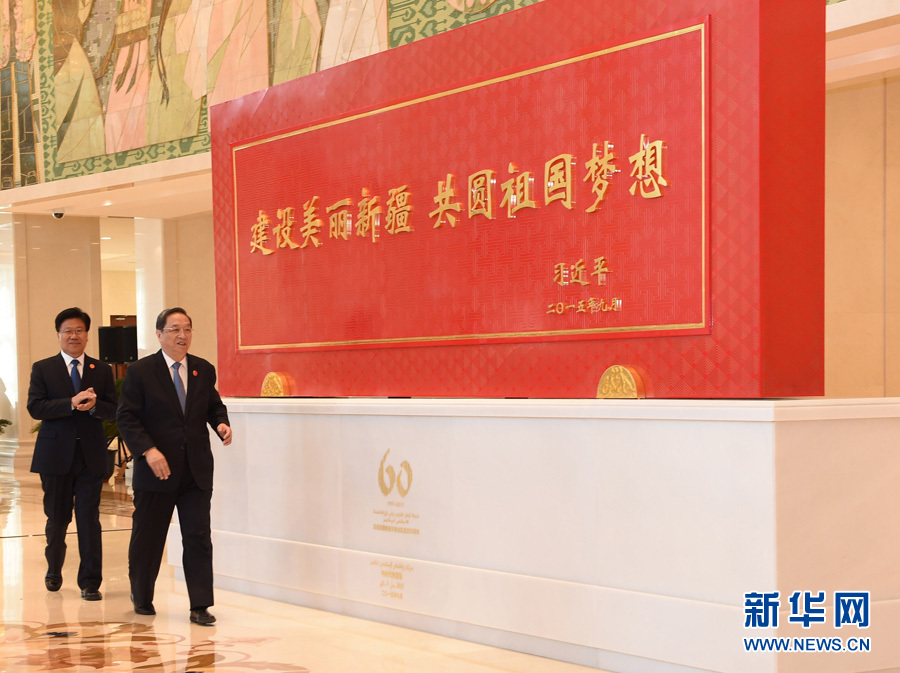 這是俞正聲和中共中央政治局委員、新疆維吾爾自治區黨委書記張春賢一同為習近平總書記題詞賀匾揭幕。新華社記者 高潔 攝 
