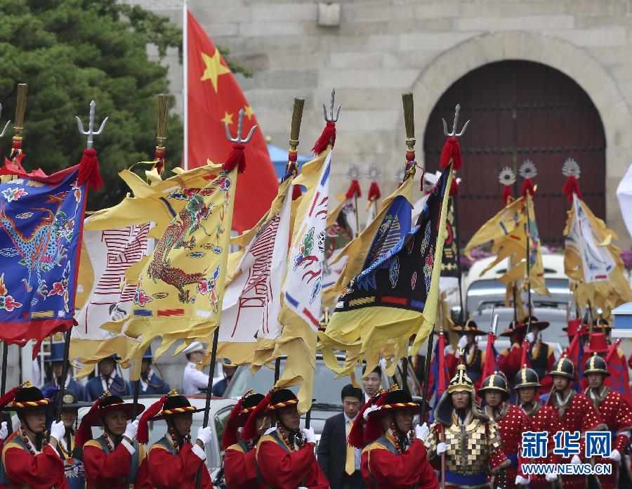 7月3日，韓國總統(tǒng)樸槿惠在青瓦臺總統(tǒng)府舉行隆重儀式，歡迎中國國家主席習近平對韓國進行國事訪問。這是習近平的車隊在身著民族服裝的韓國禮儀隊伍引導下駛?cè)肭嗤吲_。新華社記者丁林攝  